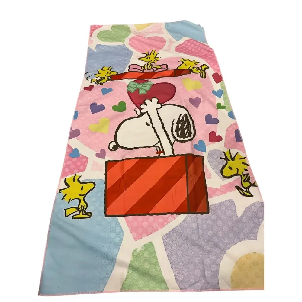 Snoopy peanuts come out of a present beach towel